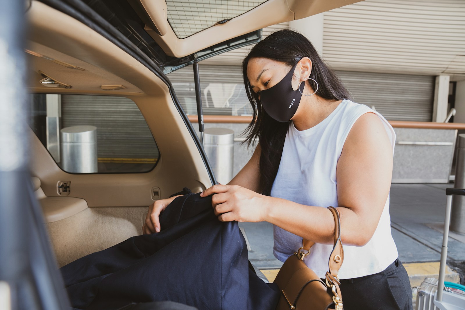 woman in white tank top wearing black sunglasses holding blue textile