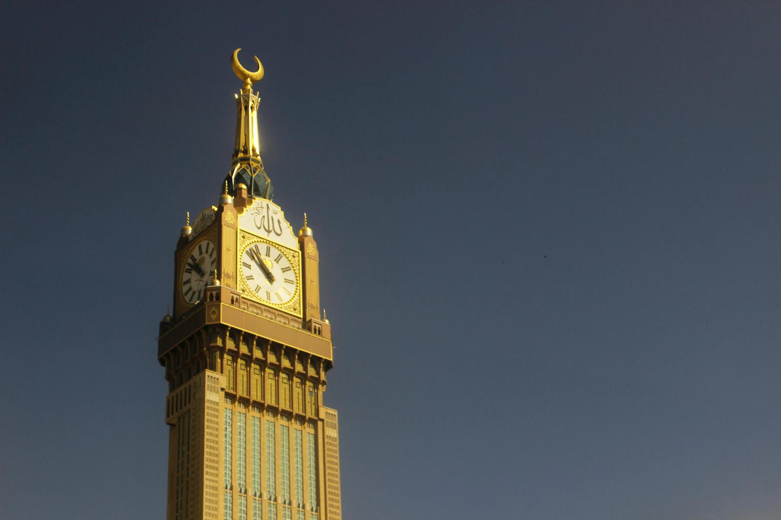 Majestic capture of the Abraj Al Bait Clock Tower in Mekkah against a clear sky.