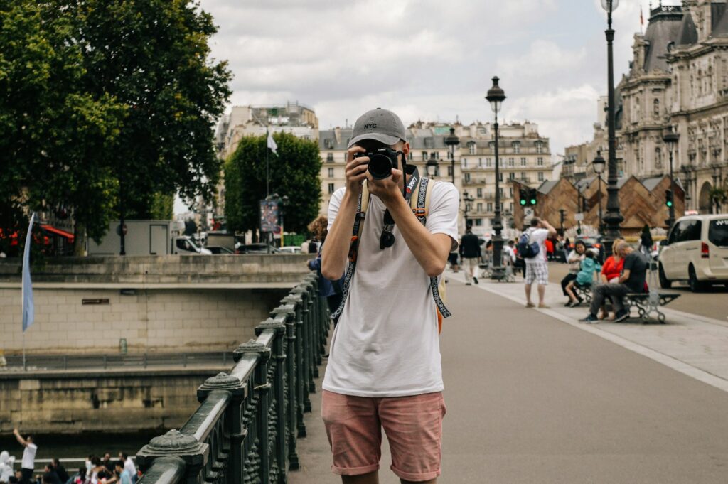 man holding DSLR camera beside bridge